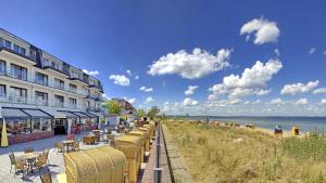 a row of tables and chairs next to a beach at Mein Strandhaus - Hotel, Restaurant & Schwimmbad in Timmendorfer Strand