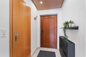 a hallway with a wooden door and a plant at Apartment Bodman in Friedrichshafen in Friedrichshafen