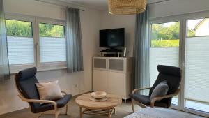a living room with two chairs and a table and a tv at Ferienwohnung Am Wall in Radeberg