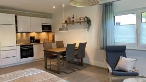 a kitchen and dining room with a table and chairs at Ferienwohnung Am Wall in Radeberg +2 photos