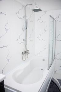 bagno con vasca e specchio di Leister Apartment Cisnadie a Cisnădie