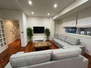 a living room with a couch and a tv at Piso lujo en Gran Vía con garaje in Vigo