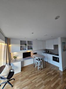 a kitchen with white cabinets and a table and chairs at Quiet, Private Studio Flat in Cambridge City Centre, CB1 in Chesterton