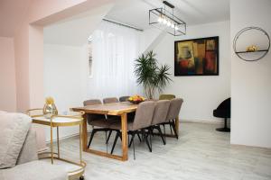 una sala da pranzo con tavolo e sedie di Leister Apartment Cisnadie a Cisnădie