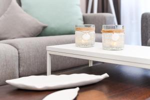 a coffee table with two mason jars with candles on it at Ferienwohnung 21 im Deichhaus 3 in Bensersiel