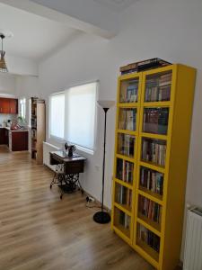 een kamer met een gele boekenplank gevuld met boeken bij Anna's in Politiká