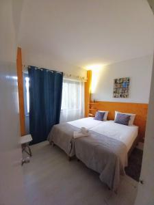 リスボンにあるCharm Discovery Principe 7のベッドルーム1室(ベッド2台、青いカーテン付)