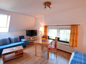 ein Wohnzimmer mit einem blauen Sofa und einem Tisch in der Unterkunft Ferienwohnungen Gross Zicker Rüg 791-2 in Groß Zicker