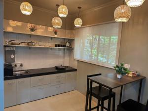 a kitchen with a table and some pendant lights at The Studio: AC, WiFi, Smart Tv in Pune