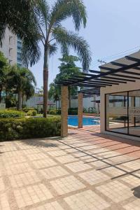 patio z palmą i basenem w obiekcie Iza's Condo in Filinvest Alabang w mieście Manila