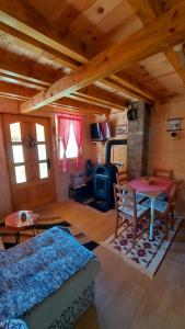 ein Wohnzimmer mit einem Tisch und einem Herd in der Unterkunft Tarska čarolija Zaovine in Popovići