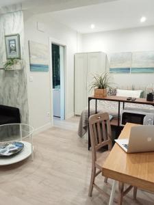 uma sala de estar com uma mesa e um computador portátil em Loft independiente FORGET ME NOT em Getxo