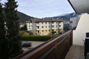 a balcony with a view of a building and a car at Areit Living corner top 21 in Zell am See