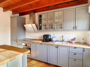 uma cozinha com armários brancos e um lavatório em Maison Pen Ar Roz - Isolée en bord de mer em Telgruc-sur-Mer