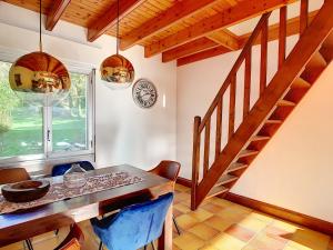 uma sala de jantar com uma mesa de madeira e uma escada em Maison Pen Ar Roz - Isolée en bord de mer em Telgruc-sur-Mer