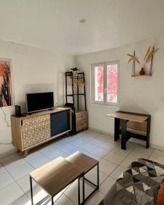 a living room with a tv and a table at Appart'Terracotta - Au cœur de Lorgues in Lorgues