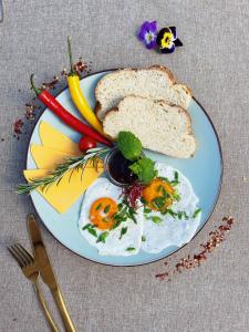 a plate of food with eggs and bread and vegetables at Rent like home - Plac Inwalidów 10 in Warsaw