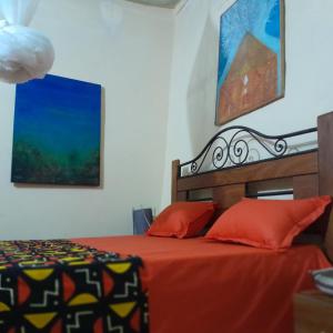 ゴレにあるNAFI'0のベッドルーム1室(オレンジ色のベッドカバー付)