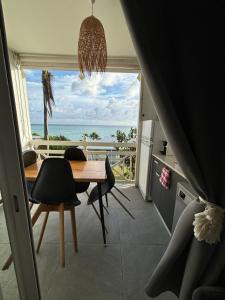 a dining room with a table and a view of the ocean at Bohème créole in Le Diamant
