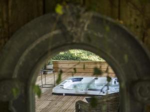 a jacuzzi tub on a wooden deck at Le Pigeonnier Colbert in Rouvray