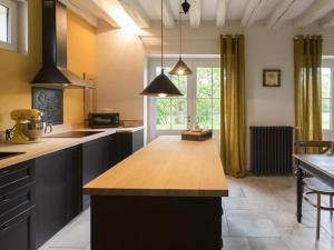 a kitchen with a large island in the middle at Le Pigeonnier Colbert in Rouvray