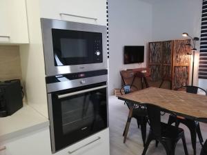 uma cozinha com um micro-ondas e uma sala de jantar com uma mesa em Azores Calheta Inn T2 Frente Boa Nova em Ponta Delgada