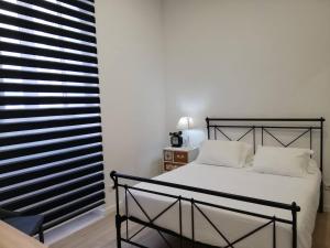 um quarto com uma cama preta e almofadas brancas em Azores Calheta Inn T2 Frente Boa Nova em Ponta Delgada