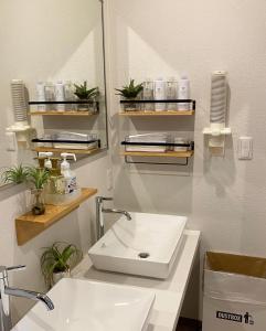 a bathroom with a sink and a mirror at AJITO Hostel & CafeBar in Shingu