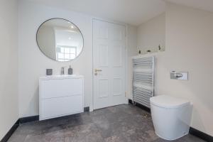 a white bathroom with a toilet and a mirror at Priorsgate in St. Andrews