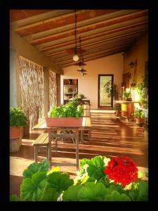 une terrasse couverte avec une table ornée de fleurs et de plantes dans l'établissement Agriturismo San Giusto, à Montiano