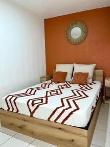 a bedroom with a large bed with orange walls at Appart'Terracotta - Au cœur de Lorgues in Lorgues