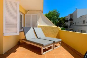 una sedia seduta sul balcone di un edificio di Hotel Cenit & Apts. Sol y Viento a Ibiza Città