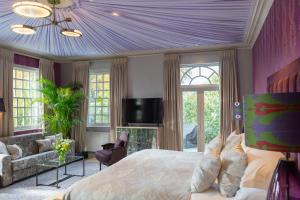 a bedroom with a large bed and a purple ceiling at Bishopstrow Hotel and Spa - Small Luxury Hotels of the World in Warminster