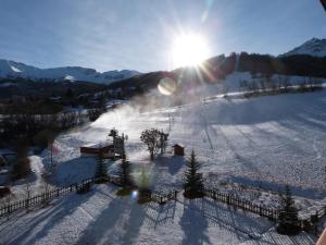 uma pista de esqui coberta de neve com o sol no céu em T2 CBU Le Sauze em Enchastrayes