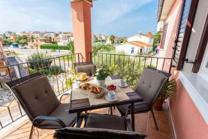 a table and chairs on a balcony with food on it at Newly renovated apartments in Funtana in Funtana