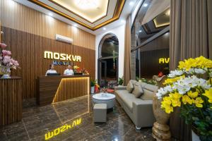 a lobby of a hotel with a couch and flowers at Moskva Motel & Apartment Danang in Danang