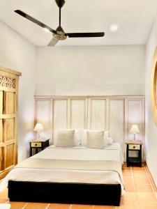 a bedroom with a large white bed with two tables at Camino a Santa Fe in Guaduas