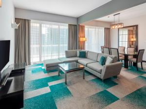 a living room with a couch and a table at Flora Creek Deluxe Hotel Apartments in Dubai