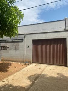 uma porta de garagem castanha num edifício cinzento em Recanto Sonho - PX Palmas Brasil em Palmas