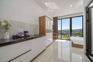 a white kitchen with a tub and a sink at Moskva Motel & Apartment Danang in Da Nang