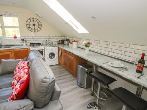 a living room with a couch and a kitchen at Woodland View in Mold