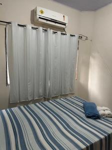 um quarto com uma cama com riscas azuis e brancas em Recanto Sonho - PX Palmas Brasil em Palmas