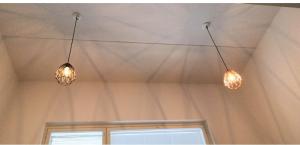 two lights hanging from the ceiling in a room at Loft next to train station & close to airport in Vantaa