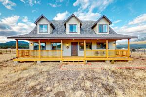 ein Haus mit einer gelben Veranda auf einem Feld in der Unterkunft 6555 N Chambers Dr in Flagstaff