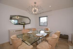 comedor con mesa de cristal y sillas en Stylish Apartment near the Airport, en Lisboa