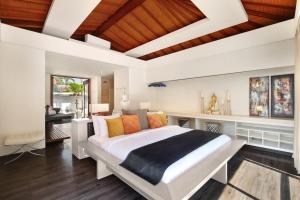 a bedroom with a large bed and a desk at The Sound of Silence - Private Villa Retreat UTOPIA for LUXXE Travellers in Tanah Lot