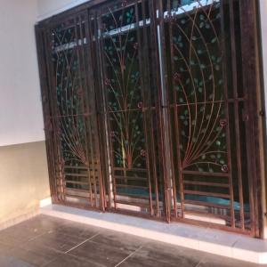 una puerta de hierro con un diseño floral en una pared en Rezqrich Villa Homestay 2, en Kampung Degong