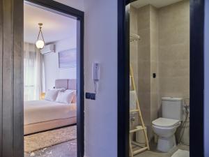 a bathroom with a bed and a toilet in a room at TheCasaEdition Gauthier Residency City Center in Casablanca