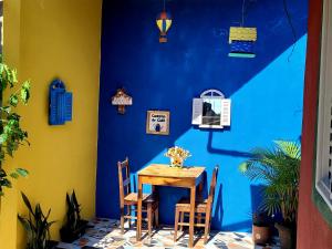 una mesa y sillas frente a una pared azul en Casinha da Vovó en São Lourenço