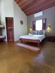a bedroom with a large bed and a window at Family Guest House in Ilha de Boipeba